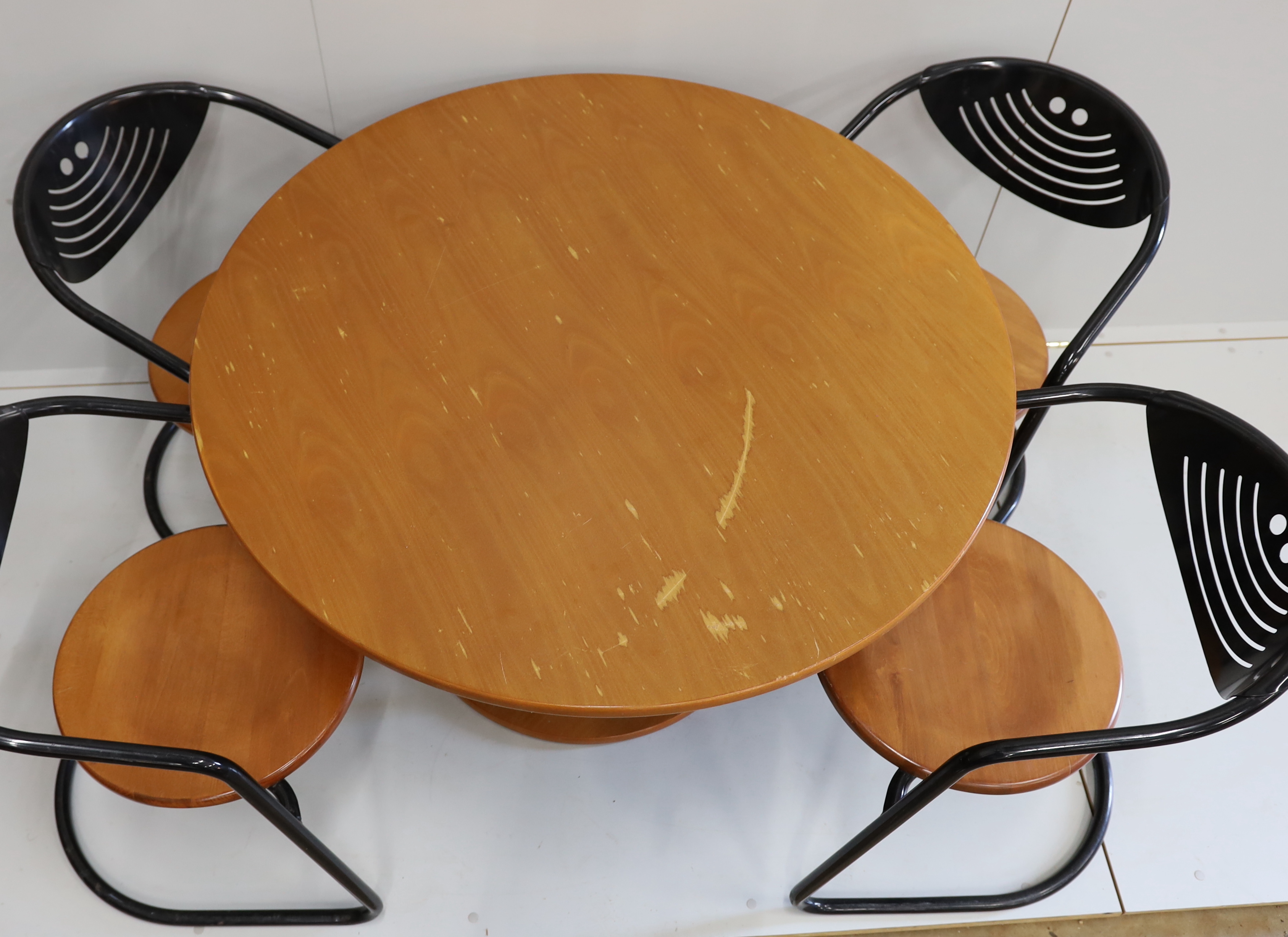 A mid century circular beech table and four cantilever chairs, table 110cm diameter, height 73cm.